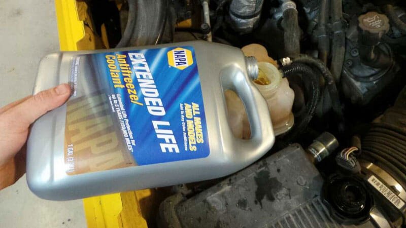 Mechanic inserting the motorcycle Coolant